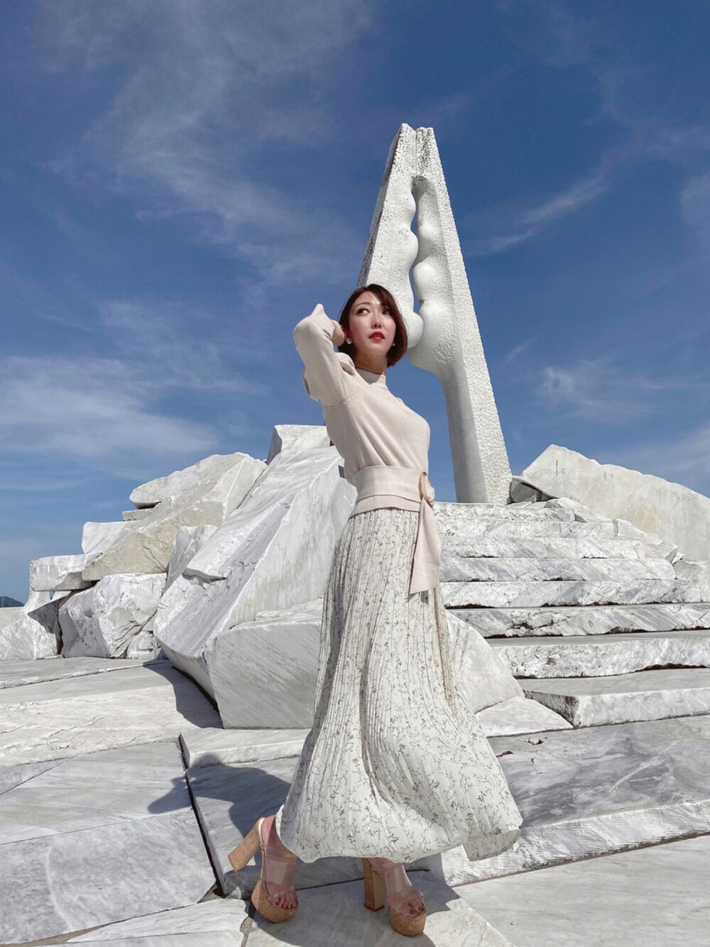 ホワイト系のスカート、ベージュ系のトップス、その他のシューズを着用したレディースの秋コーディネートの1枚目の写真