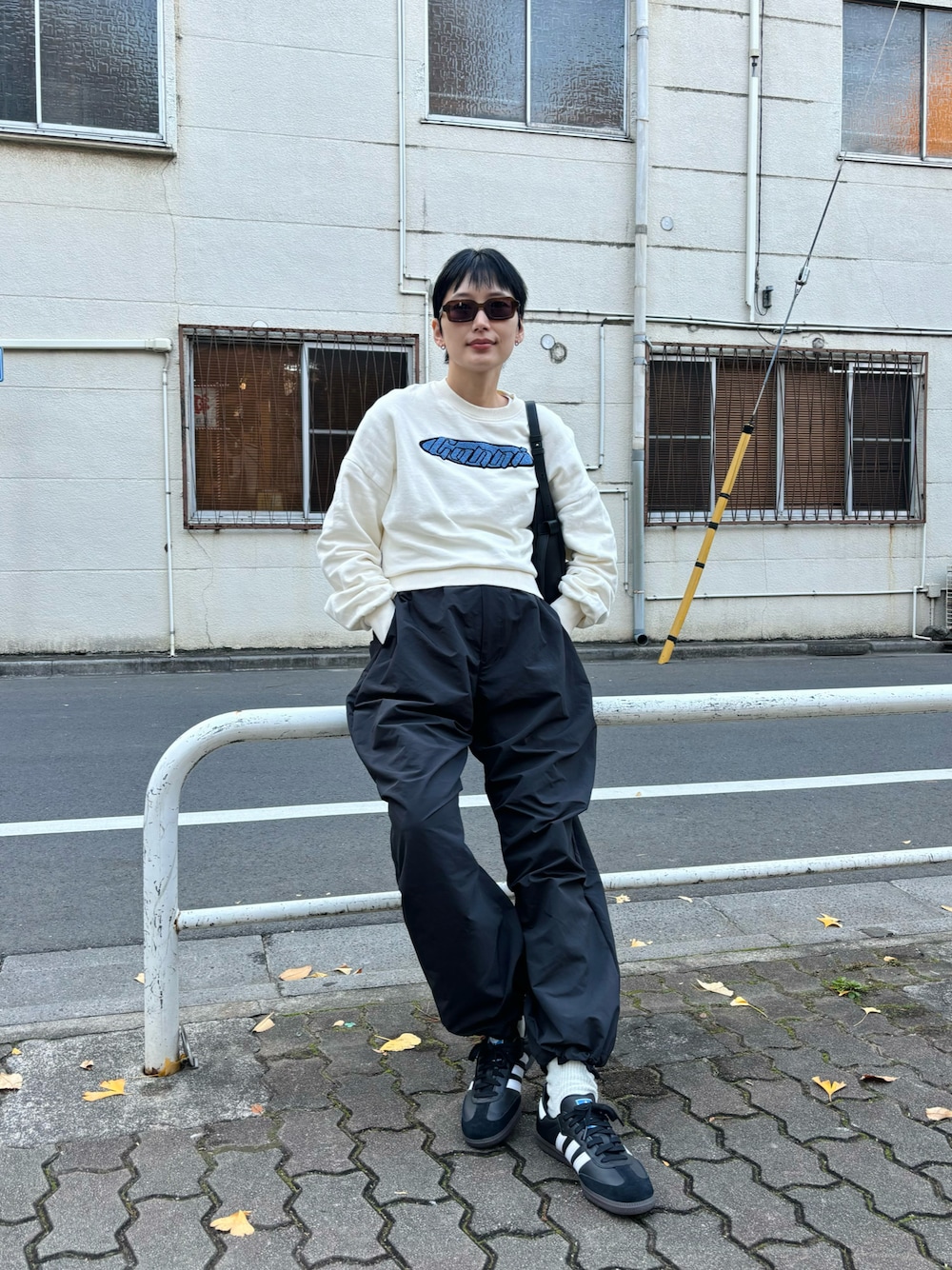 「大人カジュアル、パラシュートパンツ、スウェット、冬、シンプルコーデ、サングラス、モノトーンコーデ、サンバ」｜「GANNIの【GANNI / ガニー】 Isoli Artwork Sweatshirt：スウェット（スウェット、ホワイト系）」を使った、潮田あかりさん（レディース・166cm）の冬コーディネートの1枚目の写真
