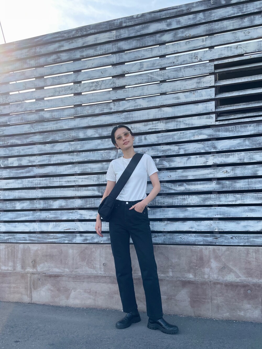 ホワイト系のTシャツ/カットソー、ブラック系のショルダーバッグ、ブラック系のブーツを着用したレディースの春コーディネートの1枚目の写真