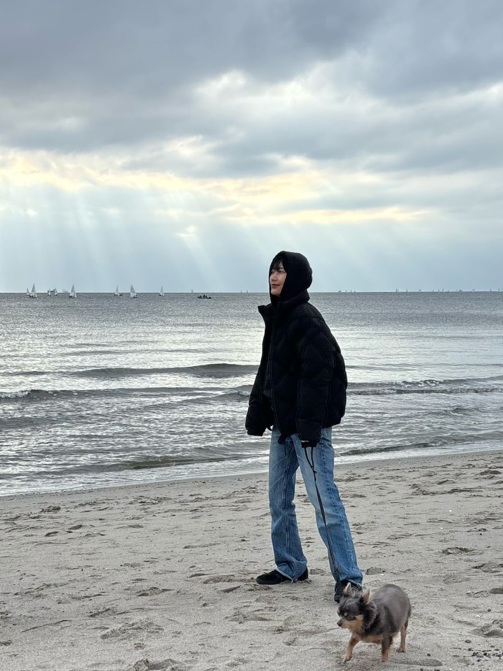 ブルー系のデニムパンツ、ブラック系のスニーカーを着用したレディースの冬コーディネートの1枚目の写真