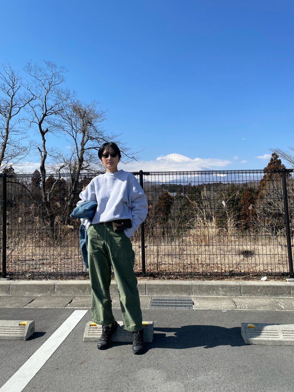 グレー系のTシャツ/カットソー、グリーン系のボディバッグ/ウエストポーチ、グリーン系のカーゴパンツを着用したレディースの春コーディネートの1枚目の写真