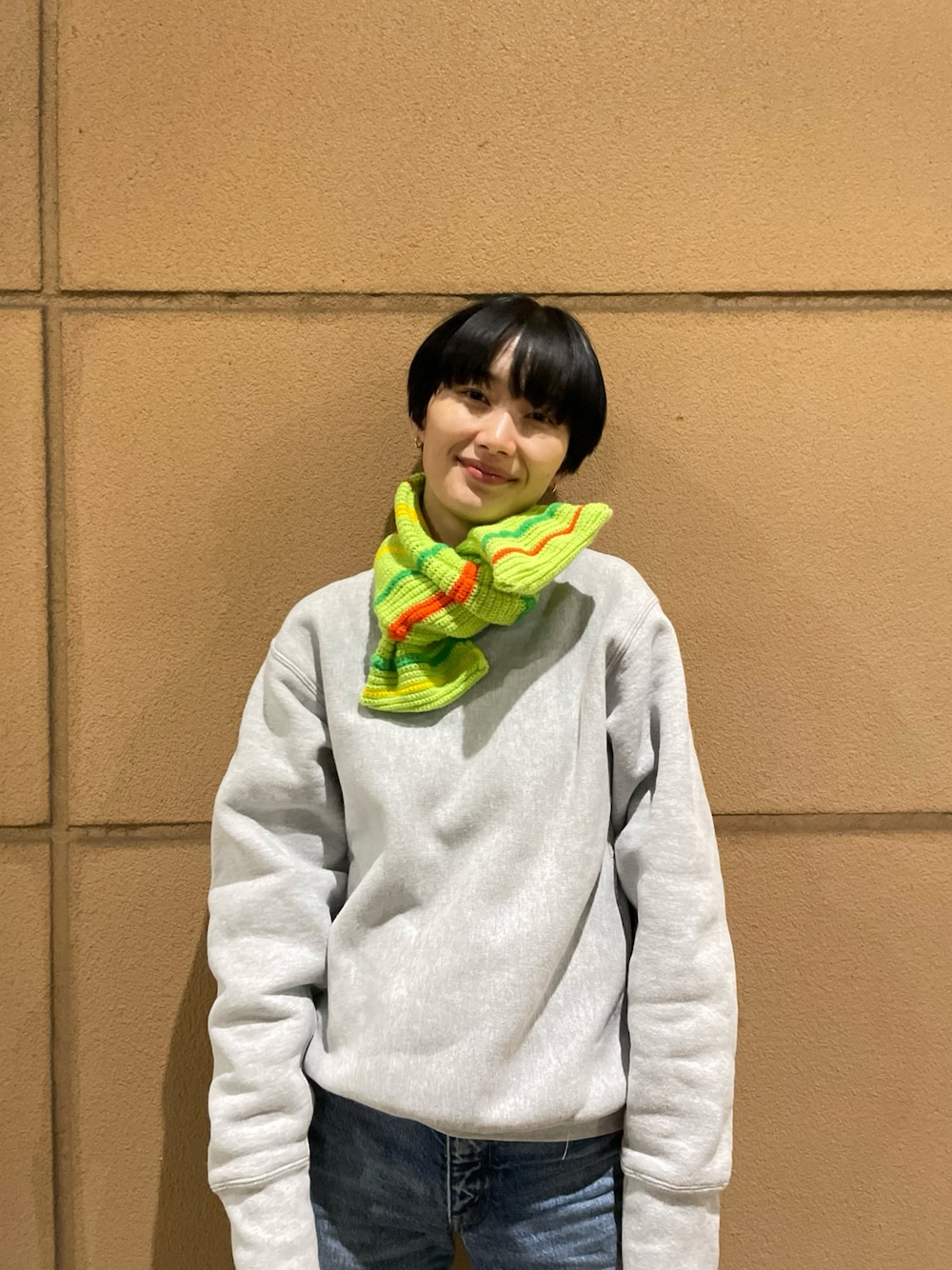 グレー系のTシャツ/カットソー、ブルー系のデニムパンツを着用したレディースの冬コーディネートの1枚目の写真