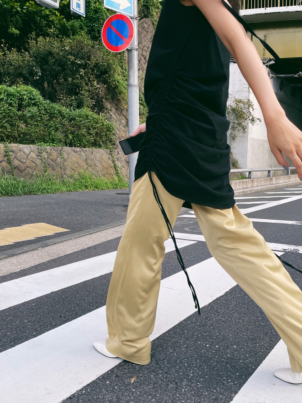 ブラック系のワンピース、イエロー系のその他パンツ、ホワイト系のパンプスを着用したレディースの夏コーディネートの1枚目の写真