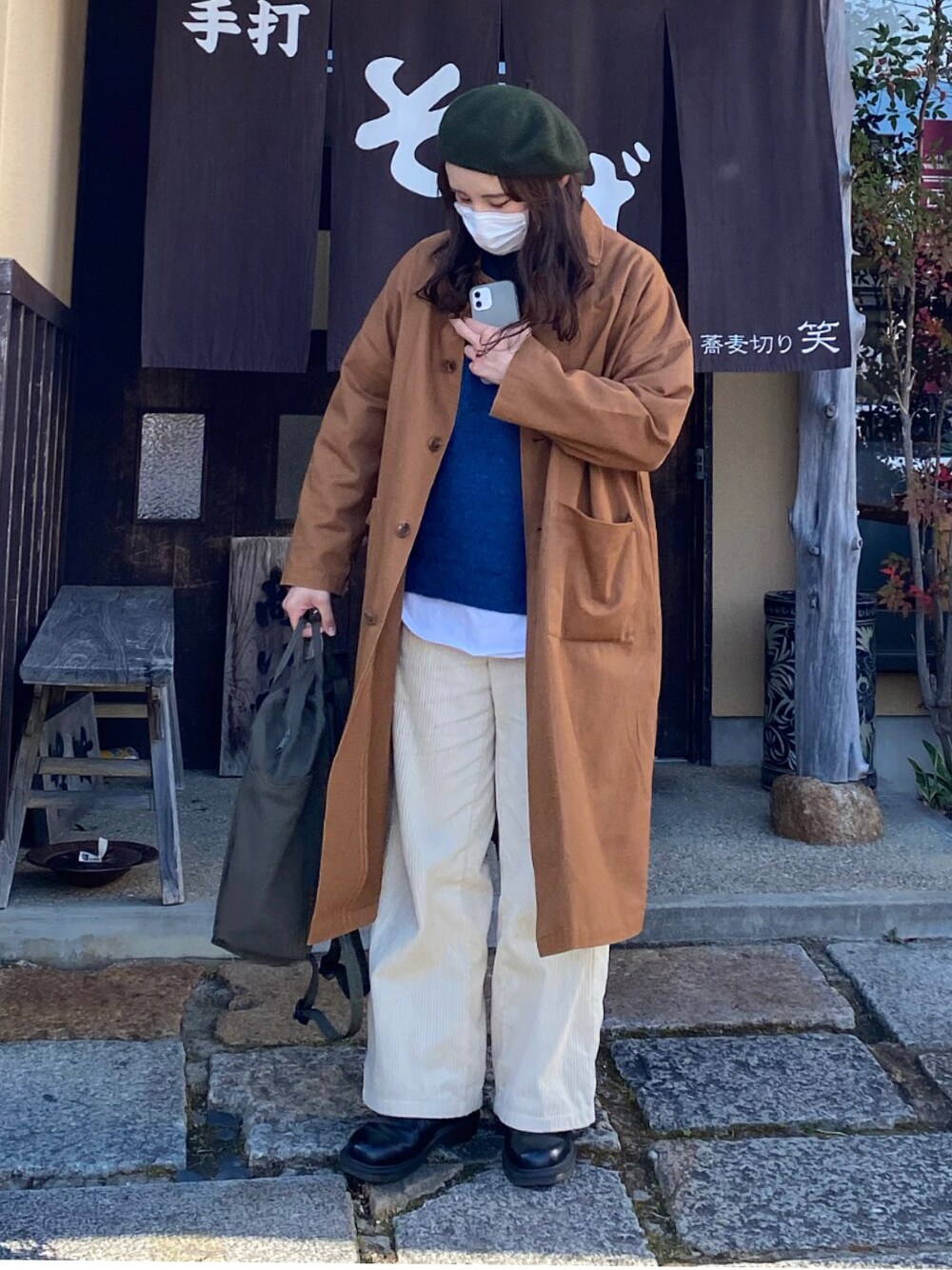 グリーン系のバックパック/リュック、ブラック系のドレスシューズ、ホワイト系のパンツを着用したレディースの冬コーディネートの1枚目の写真