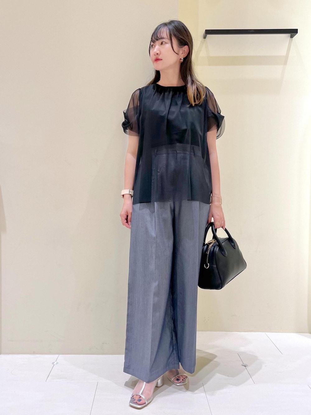 ブラック系のボストンバッグ、シルバー系のパンプス、ブラック系のTシャツ/カットソーを着用したレディースの夏コーディネートの1枚目の写真