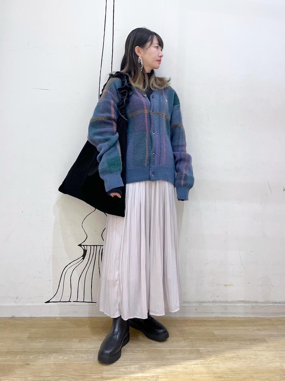 ブラック系のTシャツ/カットソー、ブルー系のカーディガン/ボレロ、グレー系のスカートを着用したレディースの秋コーディネートの1枚目の写真