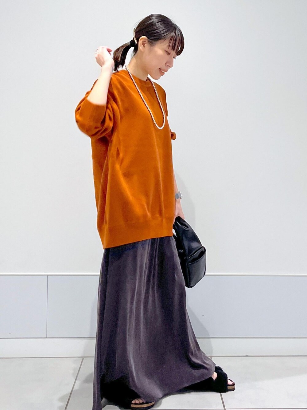 ブラック系のハンドバッグ、ブラック系のサンダル、レッド系のスウェットを着用したレディースの夏コーディネートの1枚目の写真