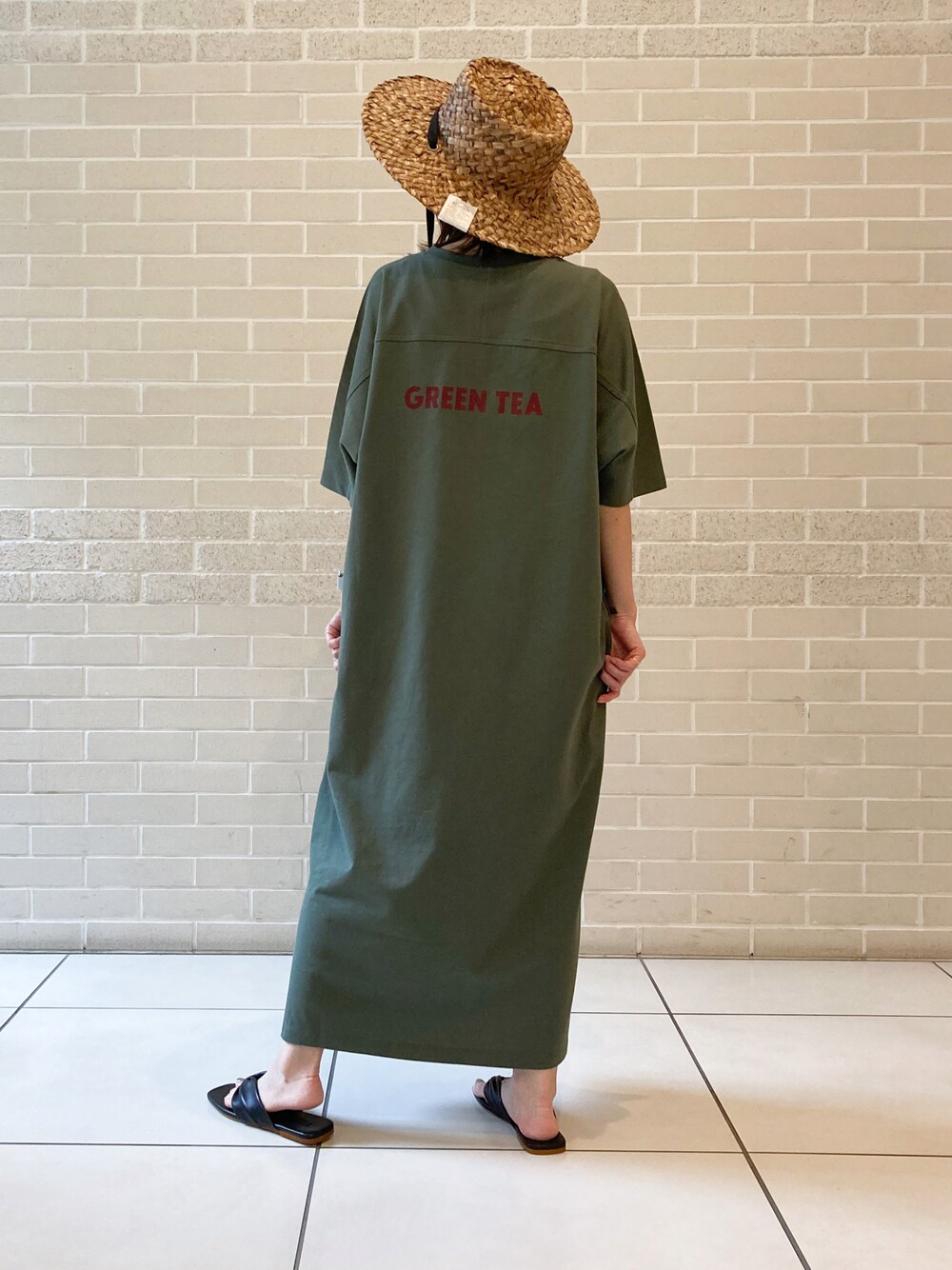 グリーン系のワンピース、ブラック系のサンダルを着用したレディースの夏コーディネートの1枚目の写真