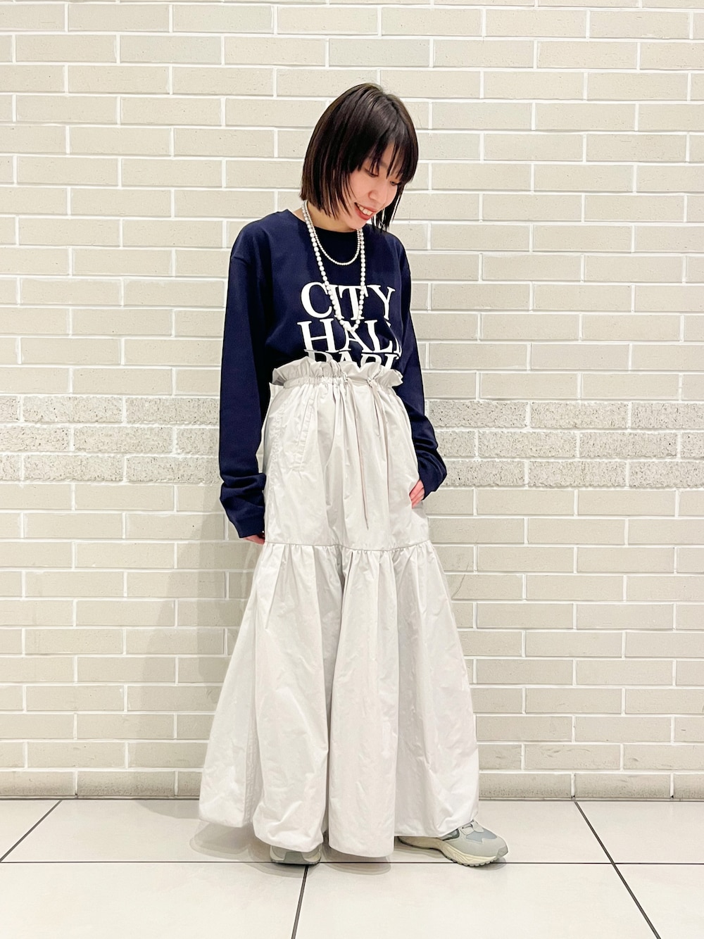ブルー系のTシャツ/カットソー、グレー系のスカート、グリーン系のスニーカーを着用したレディースの冬コーディネートの1枚目の写真