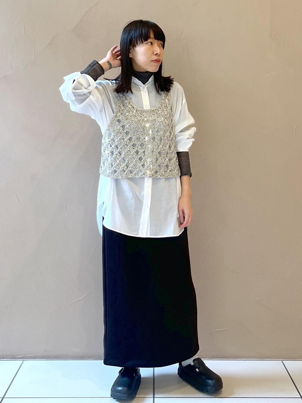 ブラック系のスカート、シルバー系のベスト、ホワイト系のシャツ/ブラウスを着用したレディースの秋コーディネートの1枚目の写真