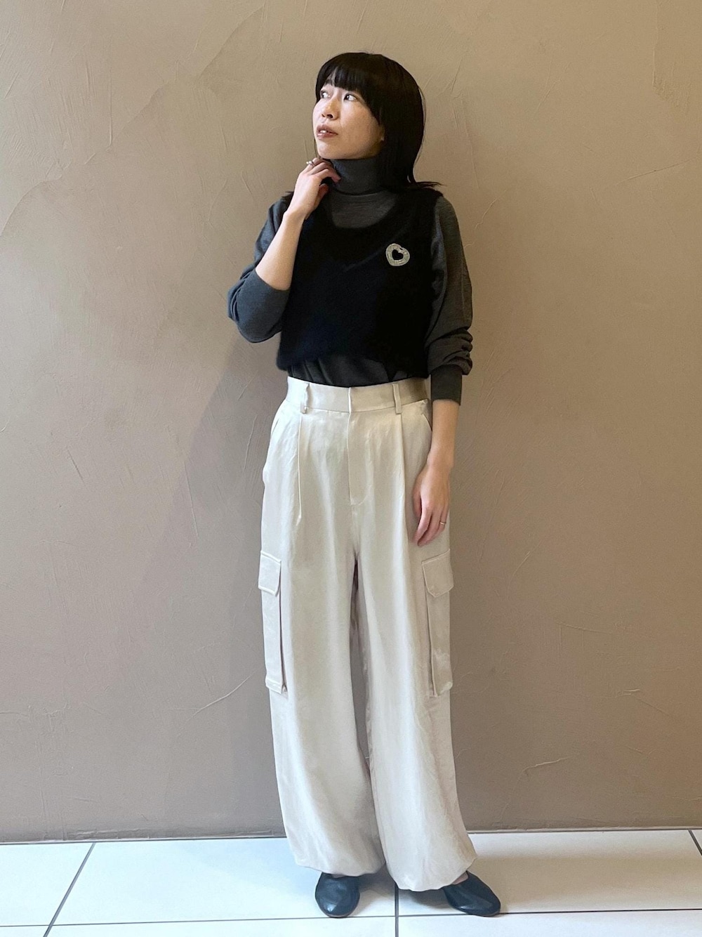 ホワイト系のカーゴパンツ、ブラック系のタンクトップ、グレー系のニット/セーターを着用したレディースの秋コーディネートの1枚目の写真
