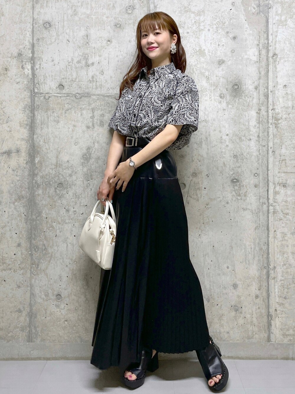 ブラック系のシャツ/ブラウス、ブラック系のスカート、ホワイト系のボストンバッグを着用したレディースの夏コーディネートの1枚目の写真