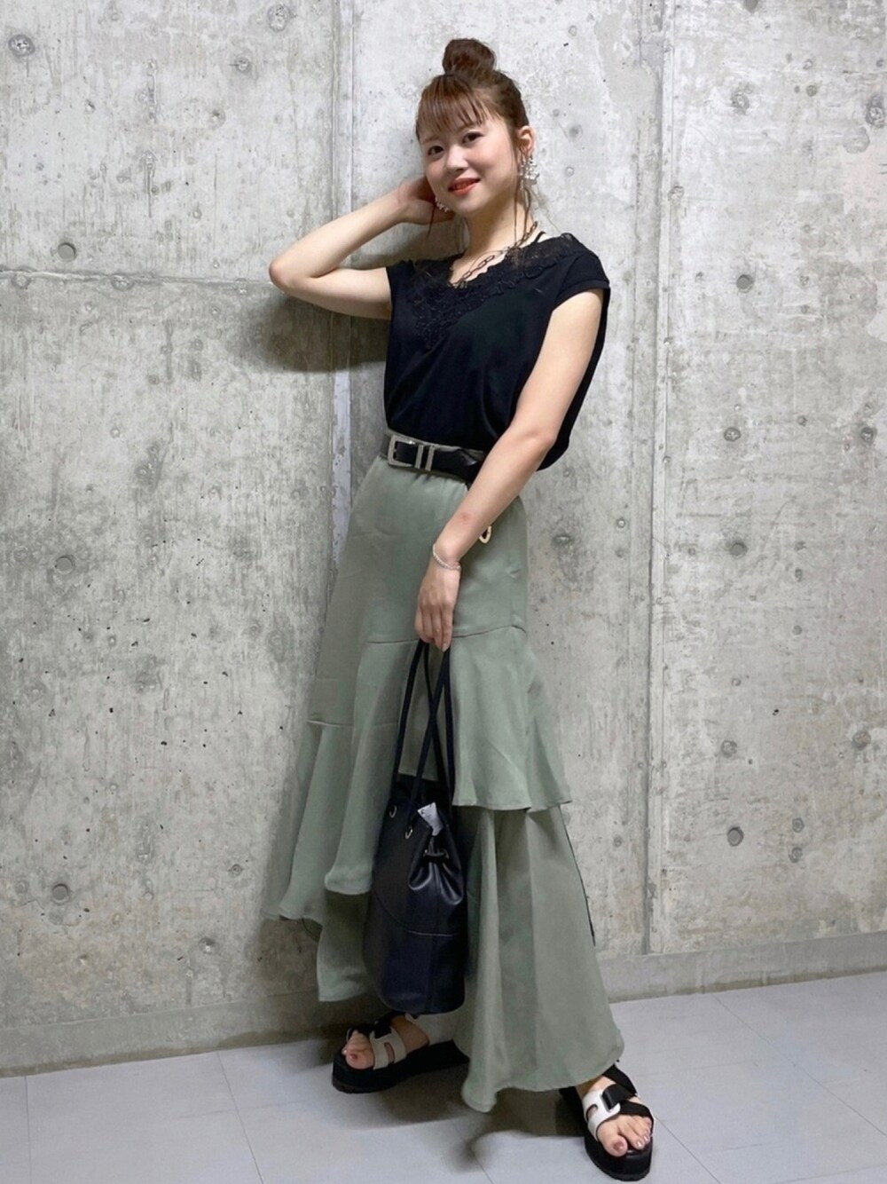 ブラック系のTシャツ/カットソー、グリーン系のスカート、ブラック系のバッグを着用したレディースの夏コーディネートの1枚目の写真
