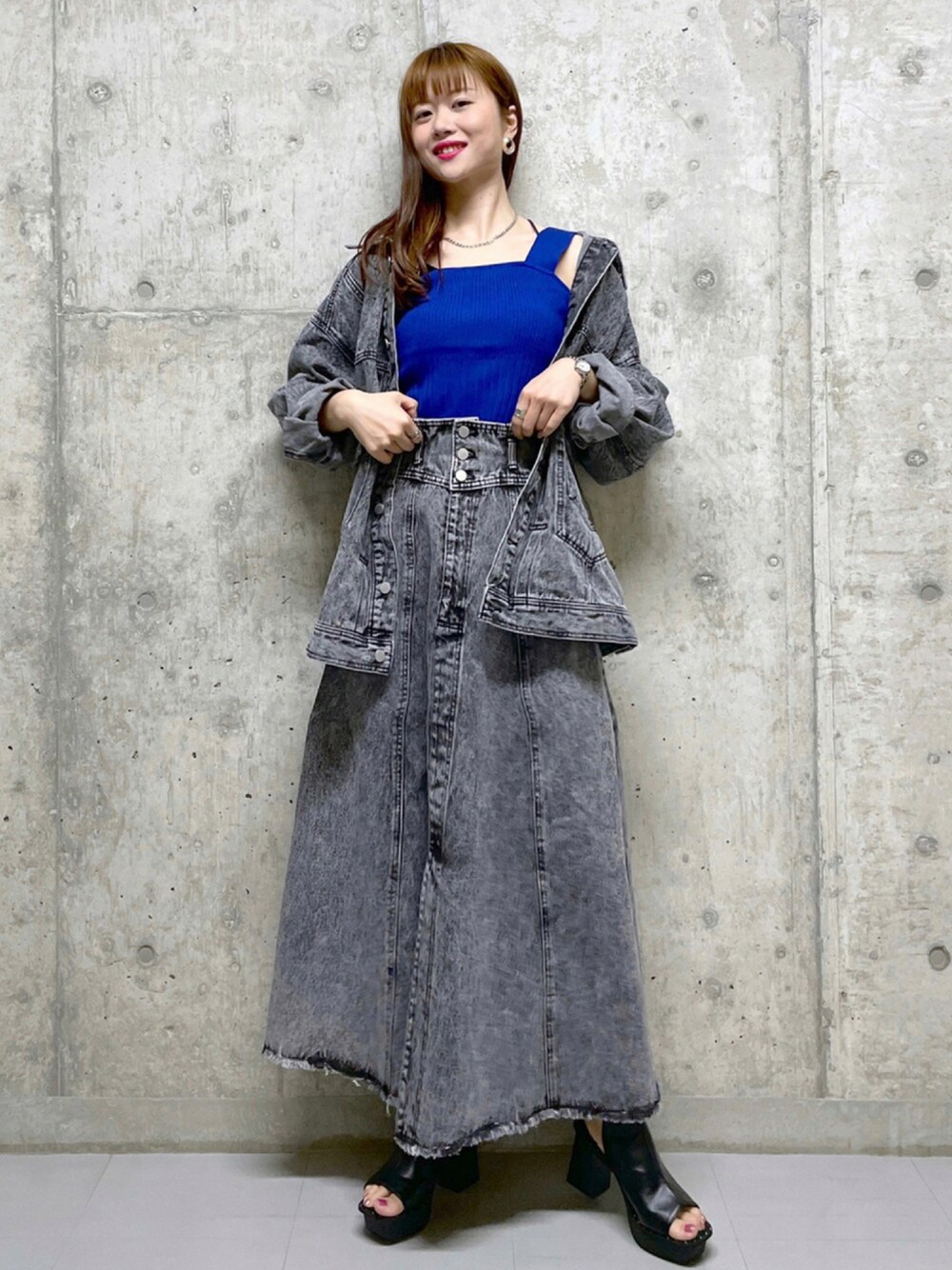 ブルー系のニット/セーター、ブラック系のジャケット/アウター、ブラック系のデニムスカートを着用したレディースの夏コーディネートの1枚目の写真