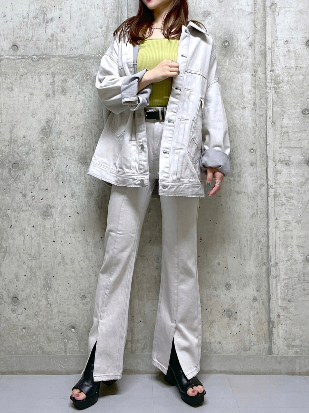 ベージュ系のデニムパンツ、イエロー系のニット/セーター、グレー系のジャケット/アウターを着用したレディースの夏コーディネートの1枚目の写真