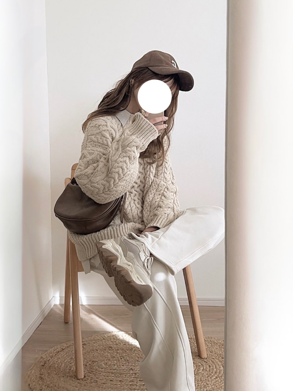 ブラウン系のニット/セーター、ホワイト系のパンツ、ブラウン系の帽子を着用したレディースの冬コーディネートの1枚目の写真