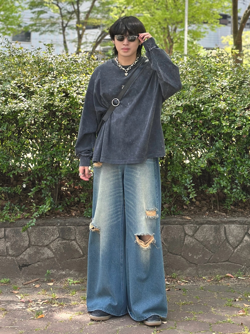 ブラック系のTシャツ/カットソー、ブラック系のショルダーバッグ、ブルー系のデニムパンツを着用したメンズの春コーディネートの1枚目の写真