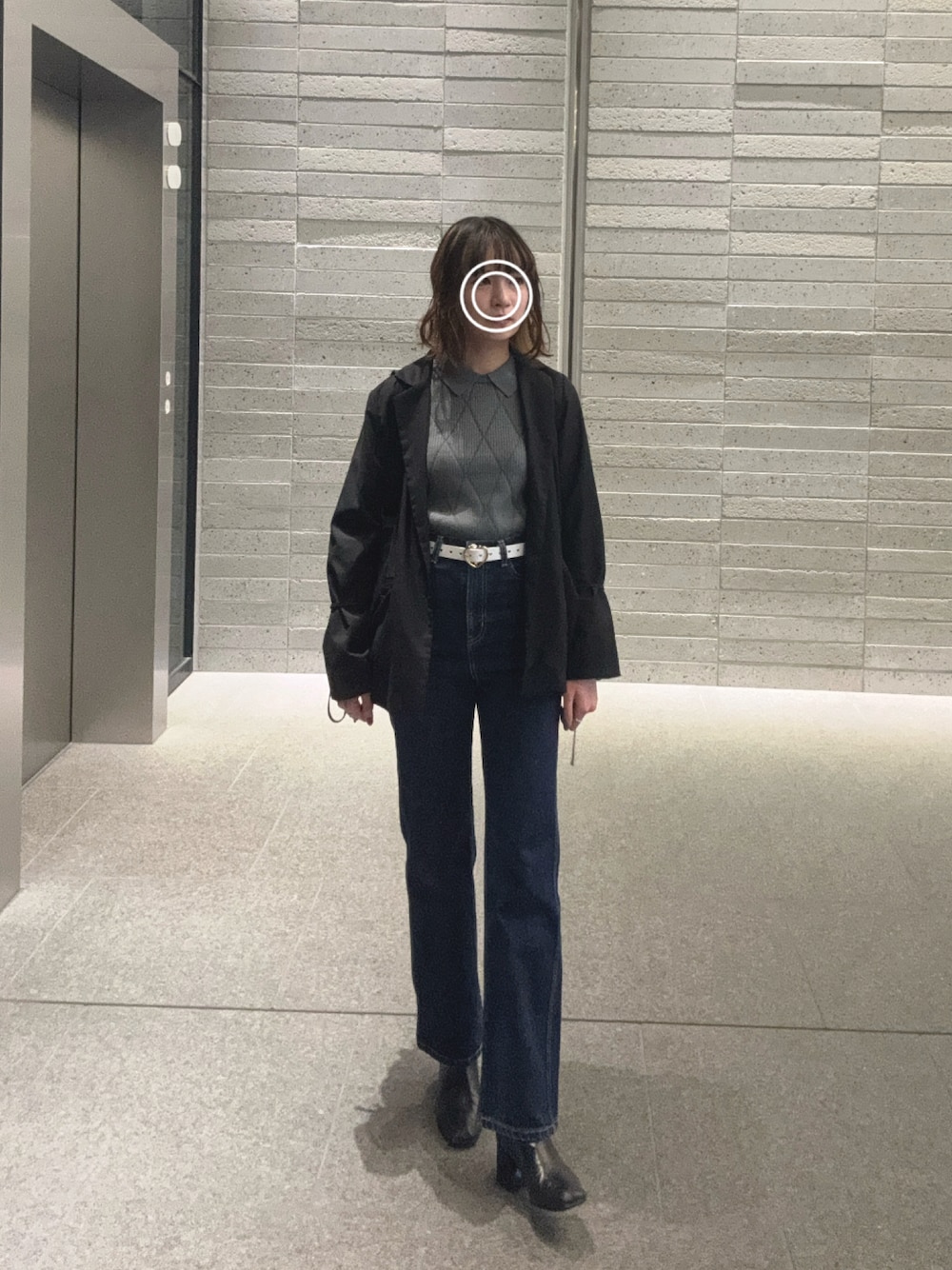 ブラック系のテーラードジャケット、ブルー系のデニムパンツ、ブラック系のブーツを着用したレディースの秋コーディネートの1枚目の写真