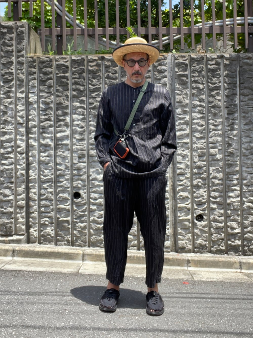 ブラック系のサンダル、ベージュ系の帽子を着用したメンズの夏コーディネートの1枚目の写真