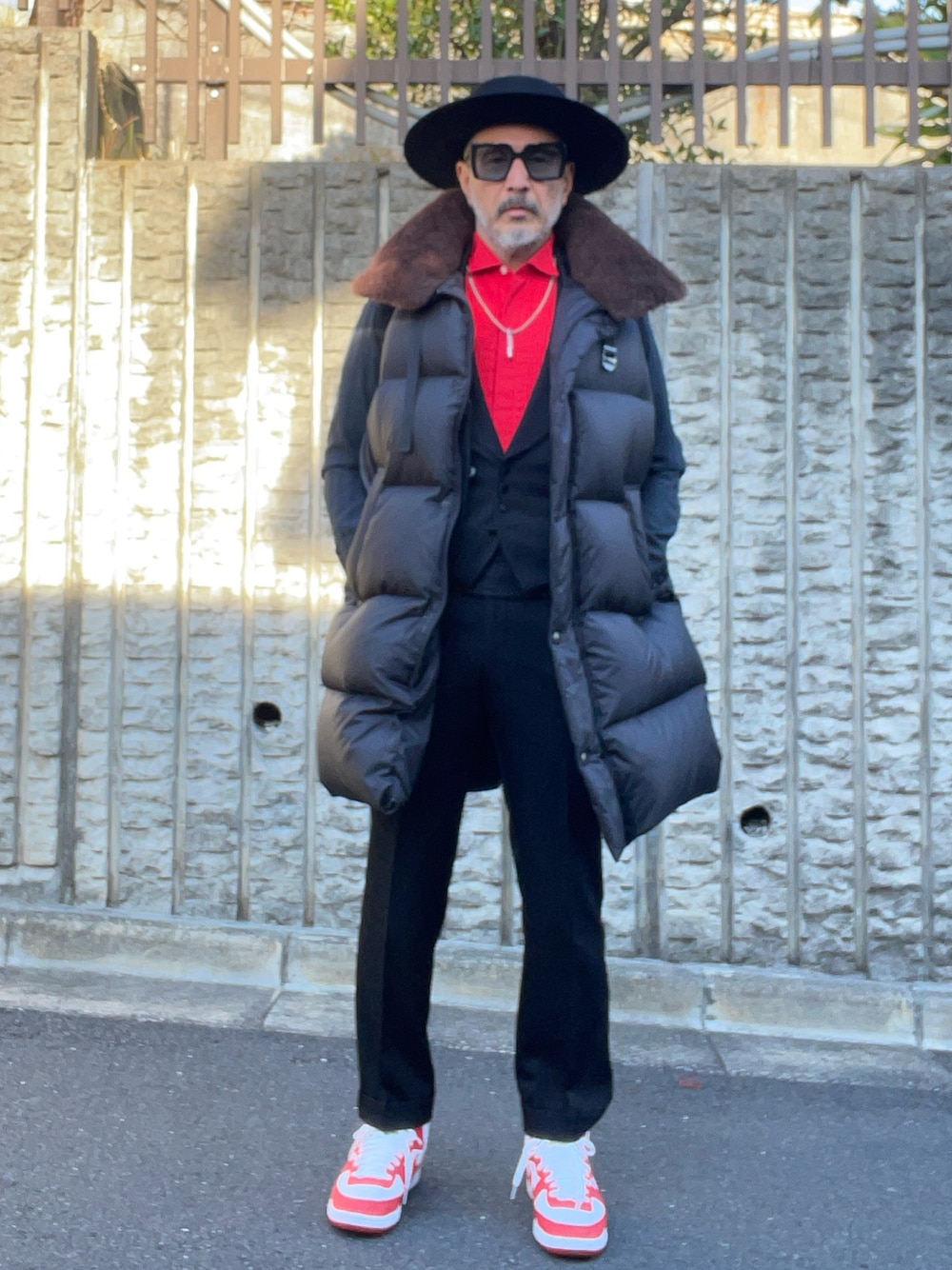 レッド系のシャツ/ブラウス、ブラック系のダウンベスト、ホワイト系のスニーカーを着用したメンズの冬コーディネートの1枚目の写真