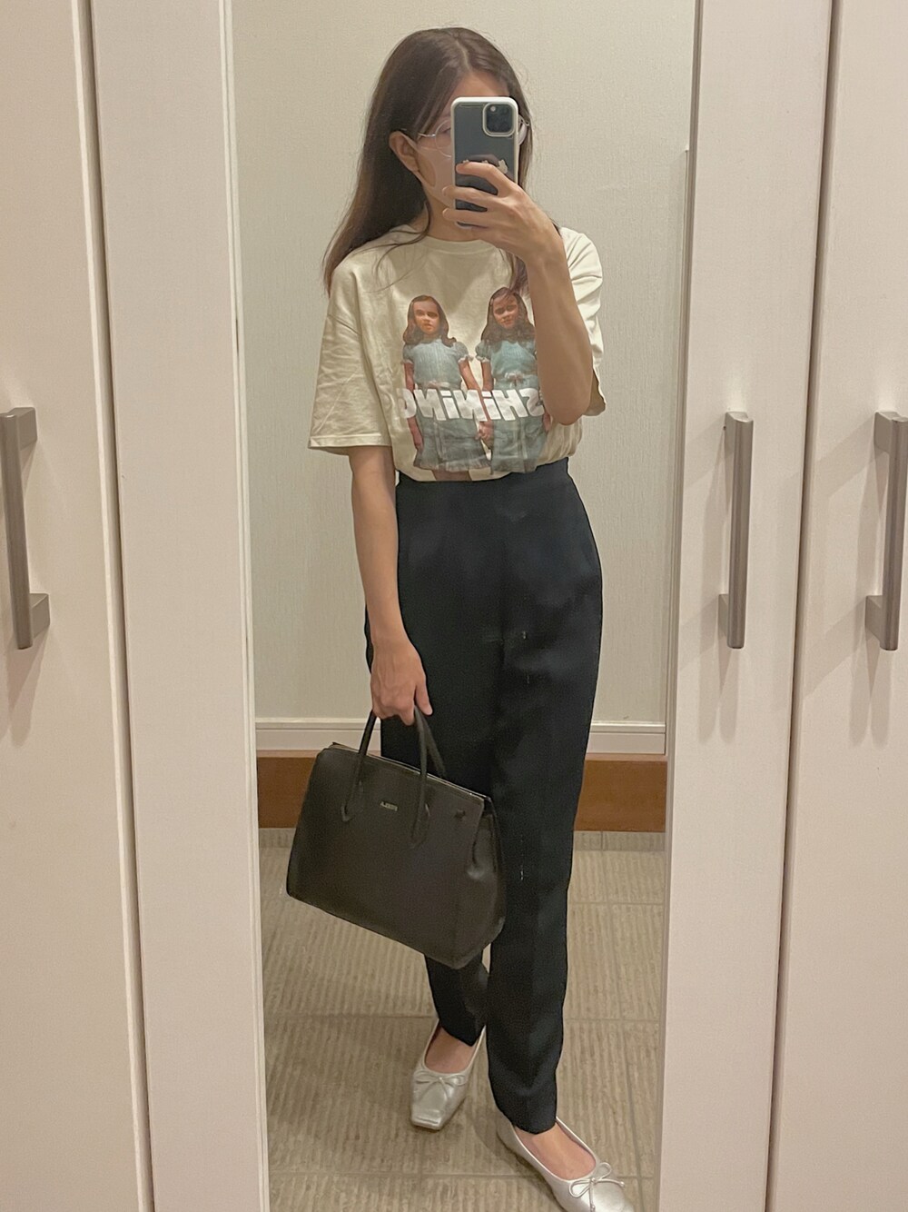 ブラック系のトートバッグ、シルバー系のパンプス、その他のTシャツ/カットソーを着用したレディースの秋コーディネートの1枚目の写真