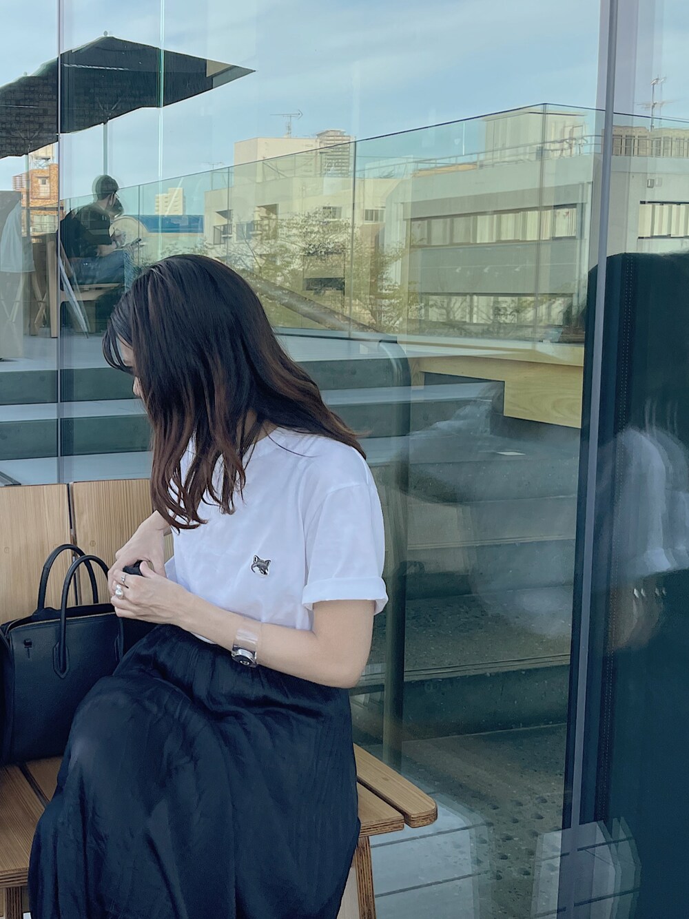 ホワイト系のTシャツ/カットソー、ブラック系のスカート、ブラック系のトートバッグを着用したレディースの秋コーディネートの1枚目の写真