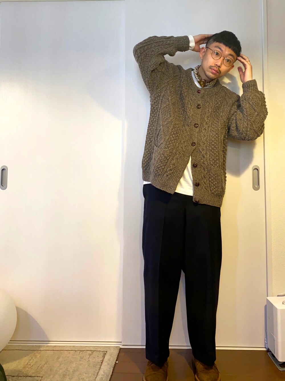 ブルー系のスラックス、ブラック系のブーツ、ブラウン系のニット/セーターを着用したメンズの冬コーディネートの1枚目の写真