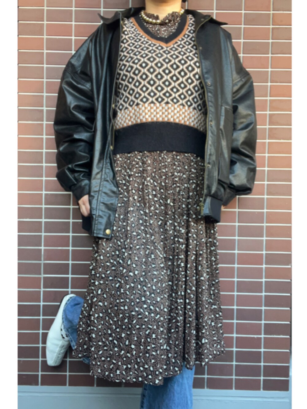 「大人カジュアル、冬コーデ、レイヤードスタイル、ブラウンコーデ、ゴールドアクセ、レザージャケット、Vネック、ジャガードニット、ベスト、柄ワンピース、プリーツワンピース、レオパード、ペタンコ靴、スクエアトゥ」｜「yuuのアイテム（ピアス（両耳用）、ゴールド系）」を使った、猫山さん（レディース・161cm）の冬コーディネートの1枚目の写真