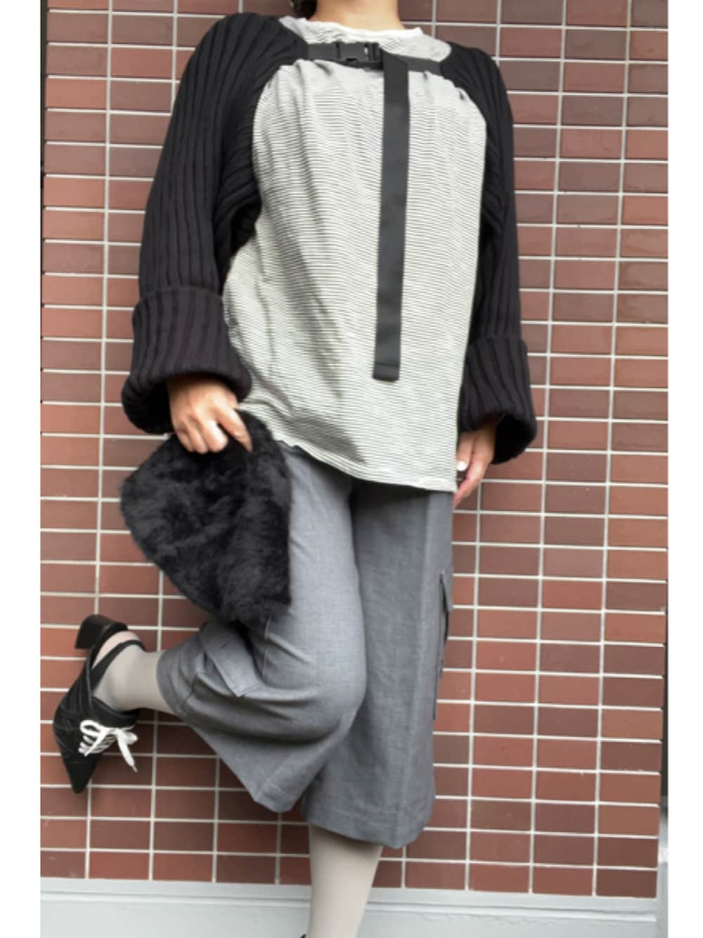 ブラック系のパンプス、ホワイト系のTシャツ/カットソー、ブラック系のカーディガン/ボレロを着用したレディースの冬コーディネートの1枚目の写真