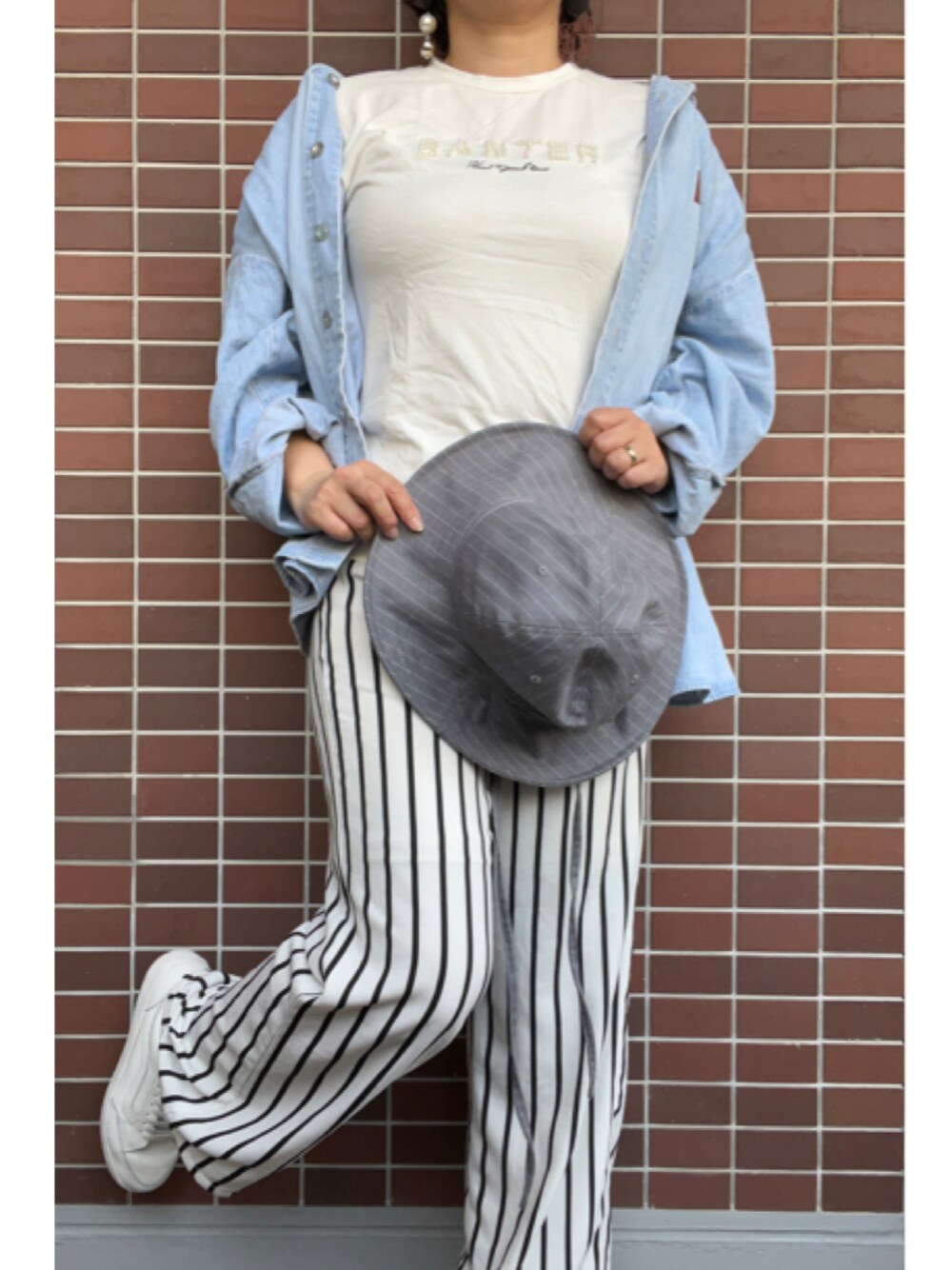 「大人カジュアル、春コーデ、休日スタイル、ハット、帽子、おおぶりピアス、デニムシャツ、パール付きトップス、白Tシャツ、ストライプパンツ、柄パンツ、白スニーカー」｜「ORIENTのアイテム（ハット、グレー系）」を使った、猫山さん（レディース・161cm）の春コーディネートの1枚目の写真