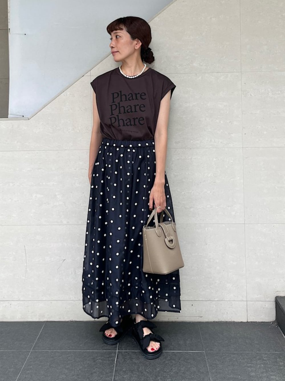 ブラック系のサンダル、ブラウン系のTシャツ/カットソー、ベージュ系のショルダーバッグを着用したレディースの夏コーディネートの1枚目の写真