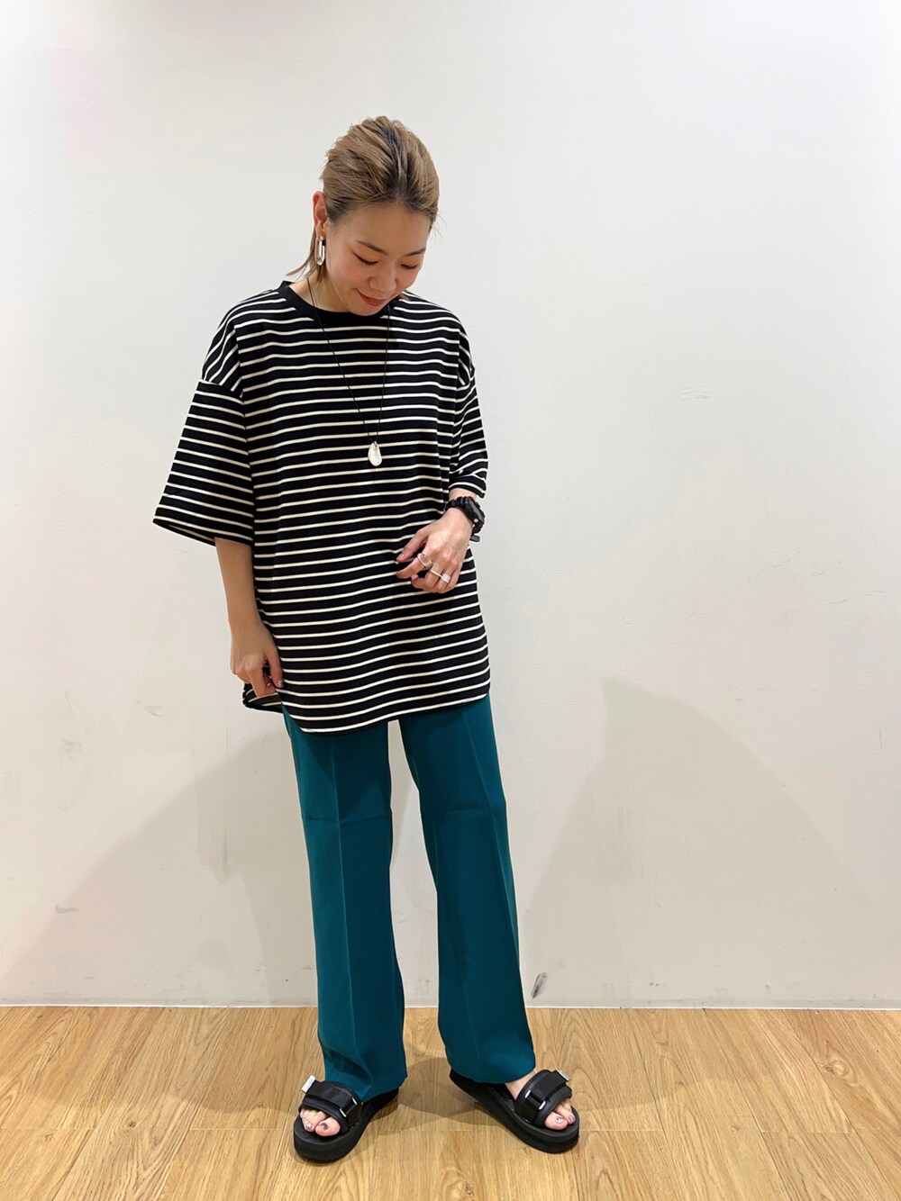 ブラック系のTシャツ/カットソー、グリーン系のスラックス、シルバー系のネックレスを着用したレディースの夏コーディネートの1枚目の写真