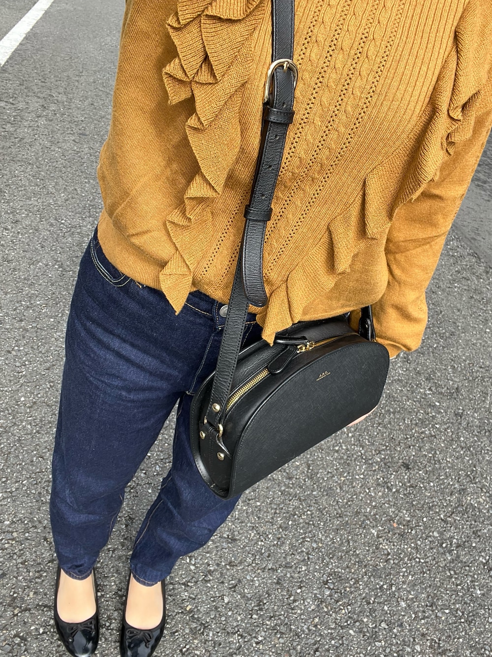 ブルー系のデニムパンツ、ブラック系のバレエシューズ、ブラック系のショルダーバッグを着用したレディースの秋コーディネートの1枚目の写真