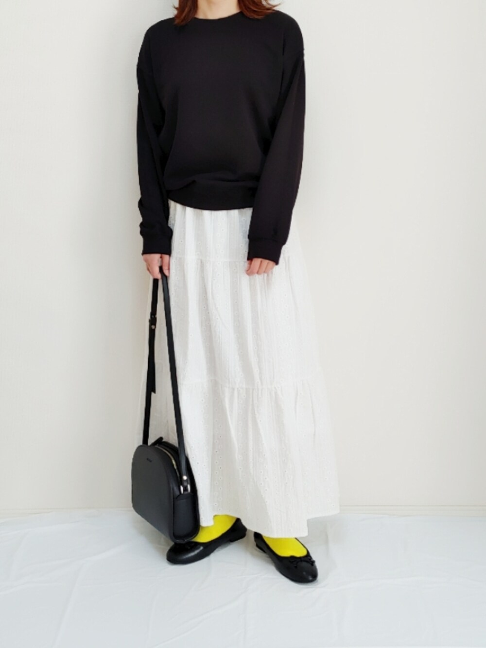 ブラック系のバレエシューズ、ブラック系のショルダーバッグを着用したレディースの春コーディネートの1枚目の写真