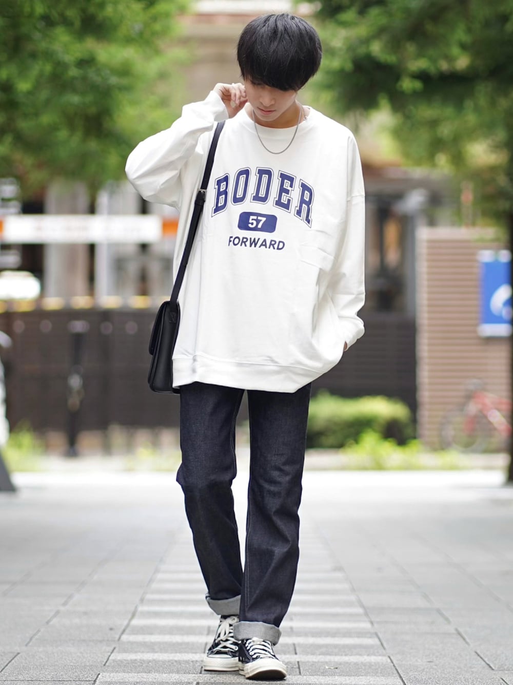 ホワイト系のTシャツ/カットソー、ブラック系のショルダーバッグ、ブラック系のデニムパンツを着用したメンズの秋コーディネートの1枚目の写真