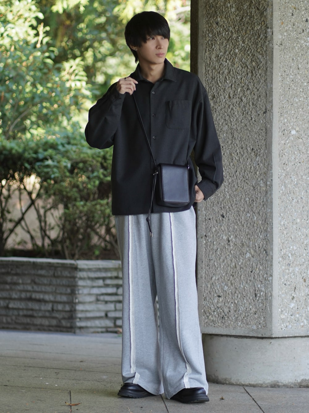 ブラック系のシャツ/ブラウス、ブラック系のモカシン/デッキシューズ、グレー系のスウェットパンツを着用したメンズの秋コーディネートの1枚目の写真