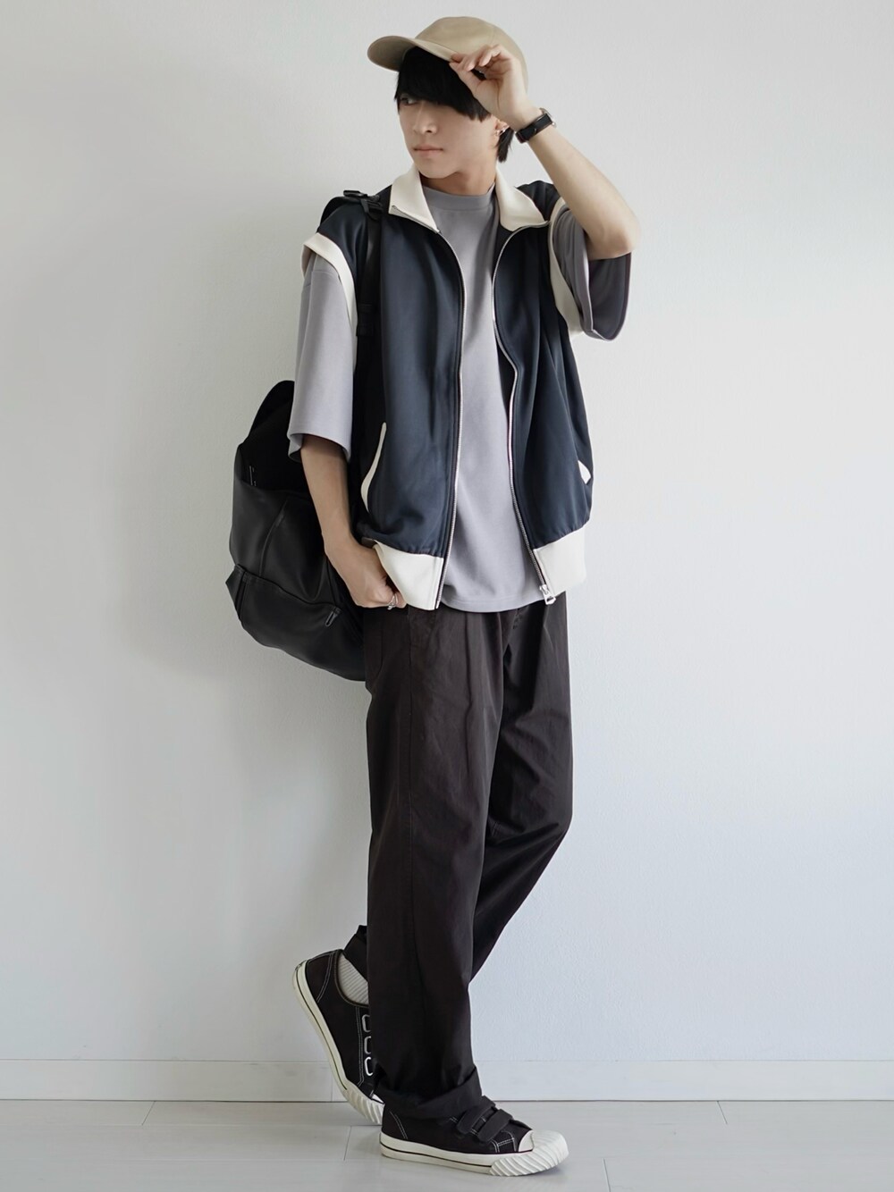 ブラック系のベスト、グレー系のTシャツ/カットソー、ブラウン系のその他パンツを着用したメンズの春コーディネートの1枚目の写真