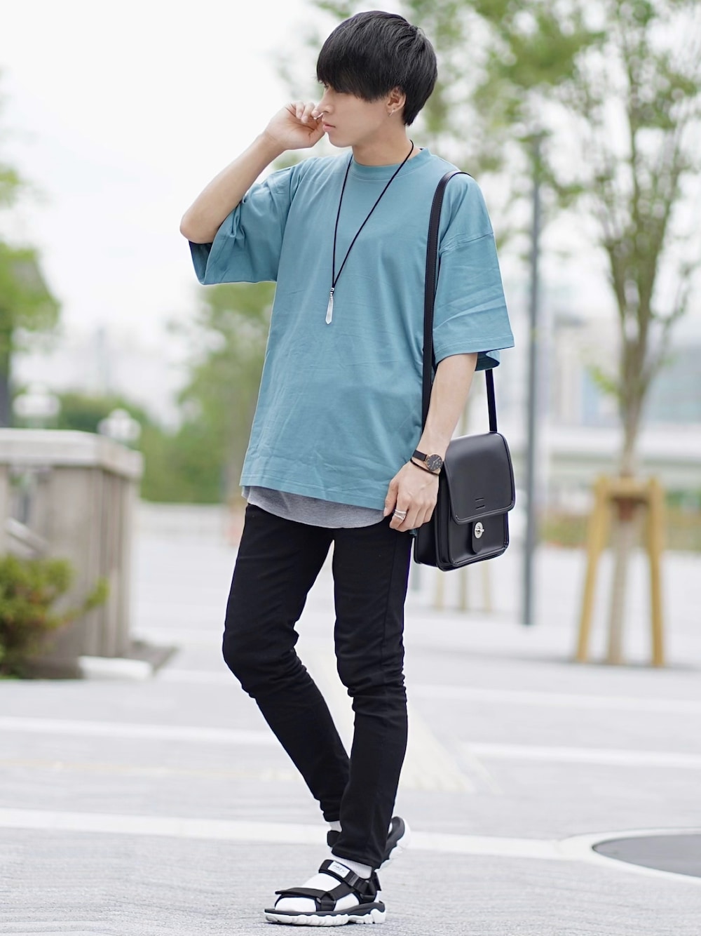 ブルー系のTシャツ/カットソー、ブラック系のショルダーバッグ、ブラック系のデニムパンツを着用したメンズの夏コーディネートの1枚目の写真