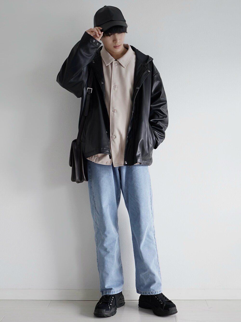 ブルー系のデニムパンツ、ブラック系のブルゾン、ホワイト系のブルゾンを着用したメンズの春コーディネートの1枚目の写真