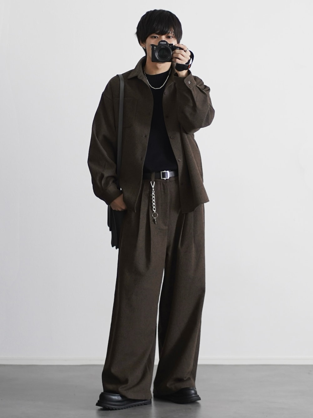 グレー系のショルダーバッグ、ブラック系のシャツ/ブラウス、ブラック系のニット/セーターを着用したメンズの秋コーディネートの1枚目の写真