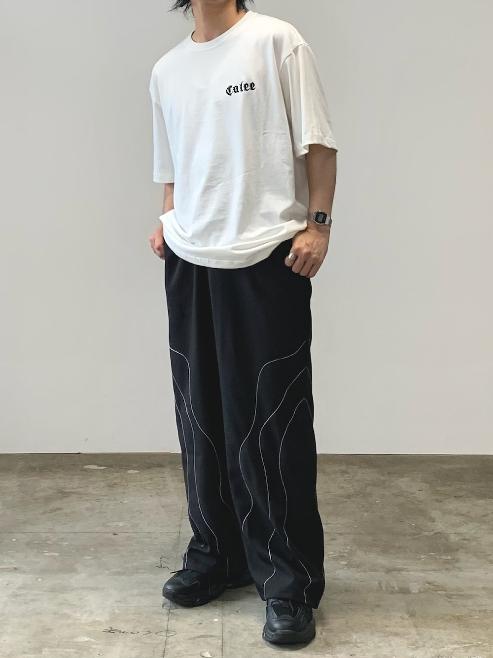 ホワイト系のTシャツ/カットソー、ブラック系のスラックスを着用したメンズの夏コーディネートの1枚目の写真