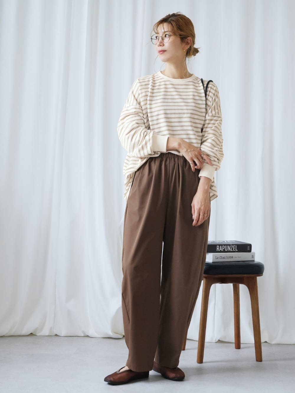 ベージュ系のTシャツ/カットソー、ブラウン系のその他パンツを着用したレディースの秋コーディネートの1枚目の写真