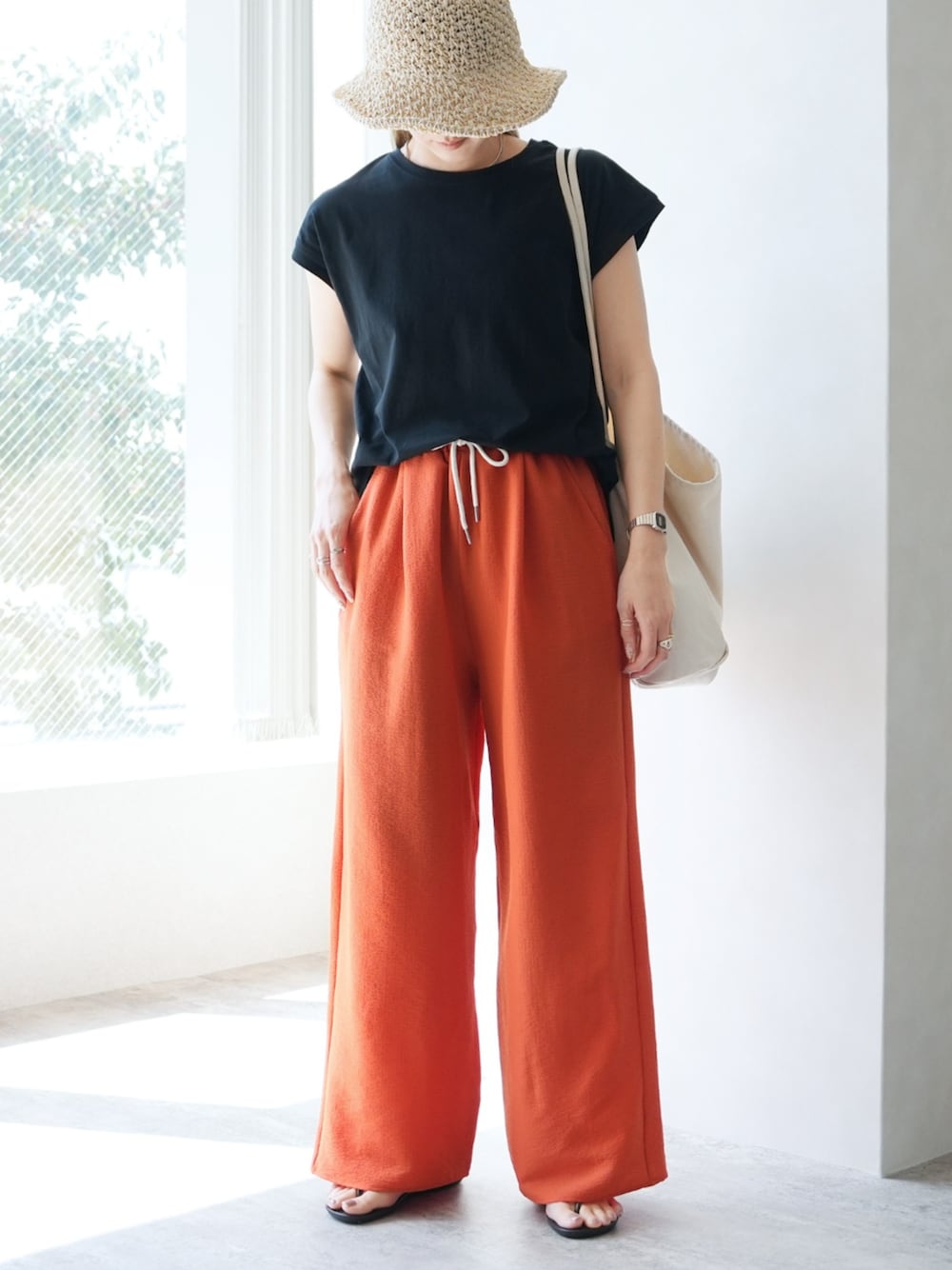 ブラック系のTシャツ/カットソー、オレンジ系のその他パンツを着用したレディースの夏コーディネートの1枚目の写真