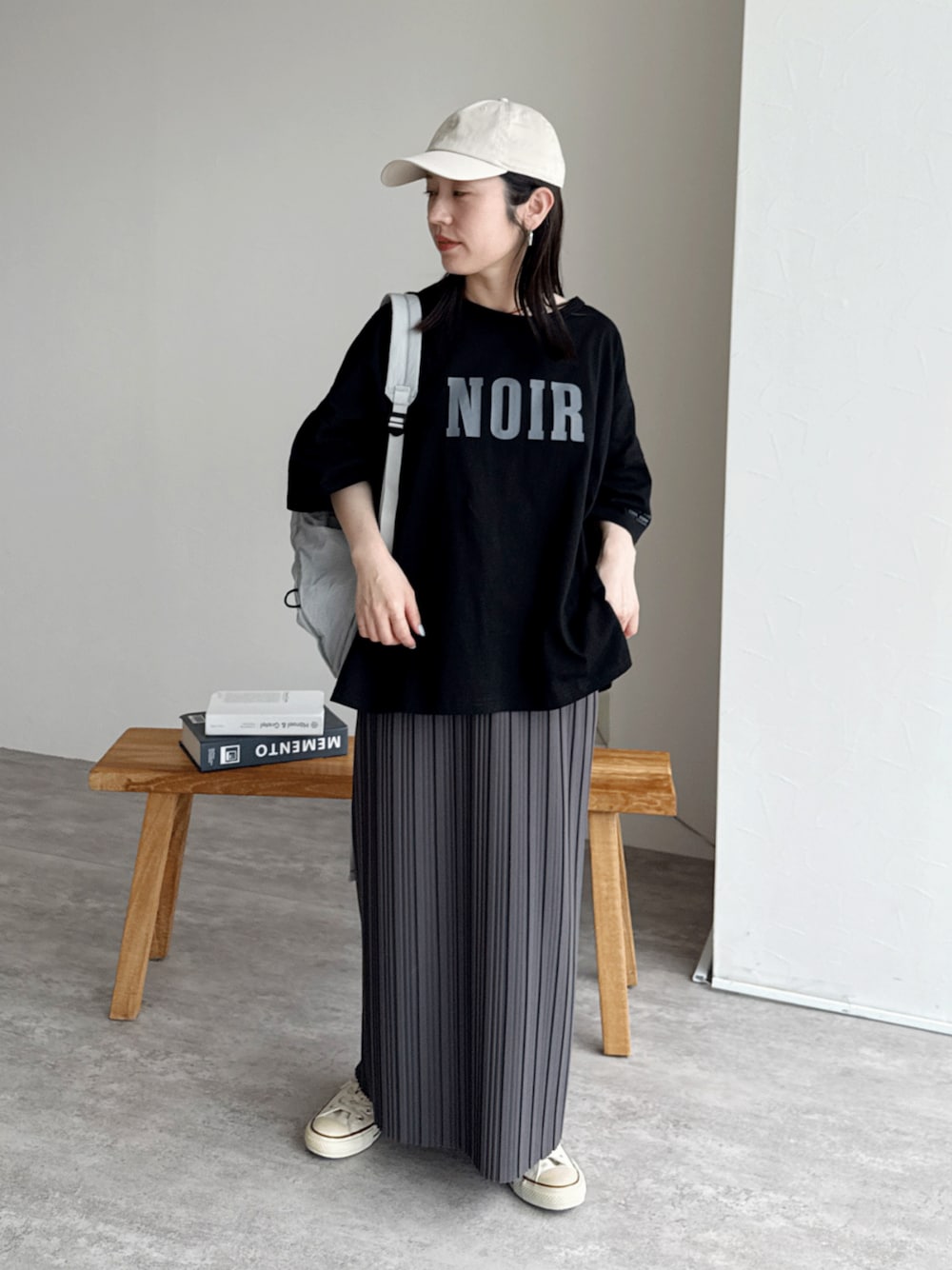 グレー系のスカート、ブラック系のTシャツ/カットソーを着用したレディースの夏コーディネートの1枚目の写真