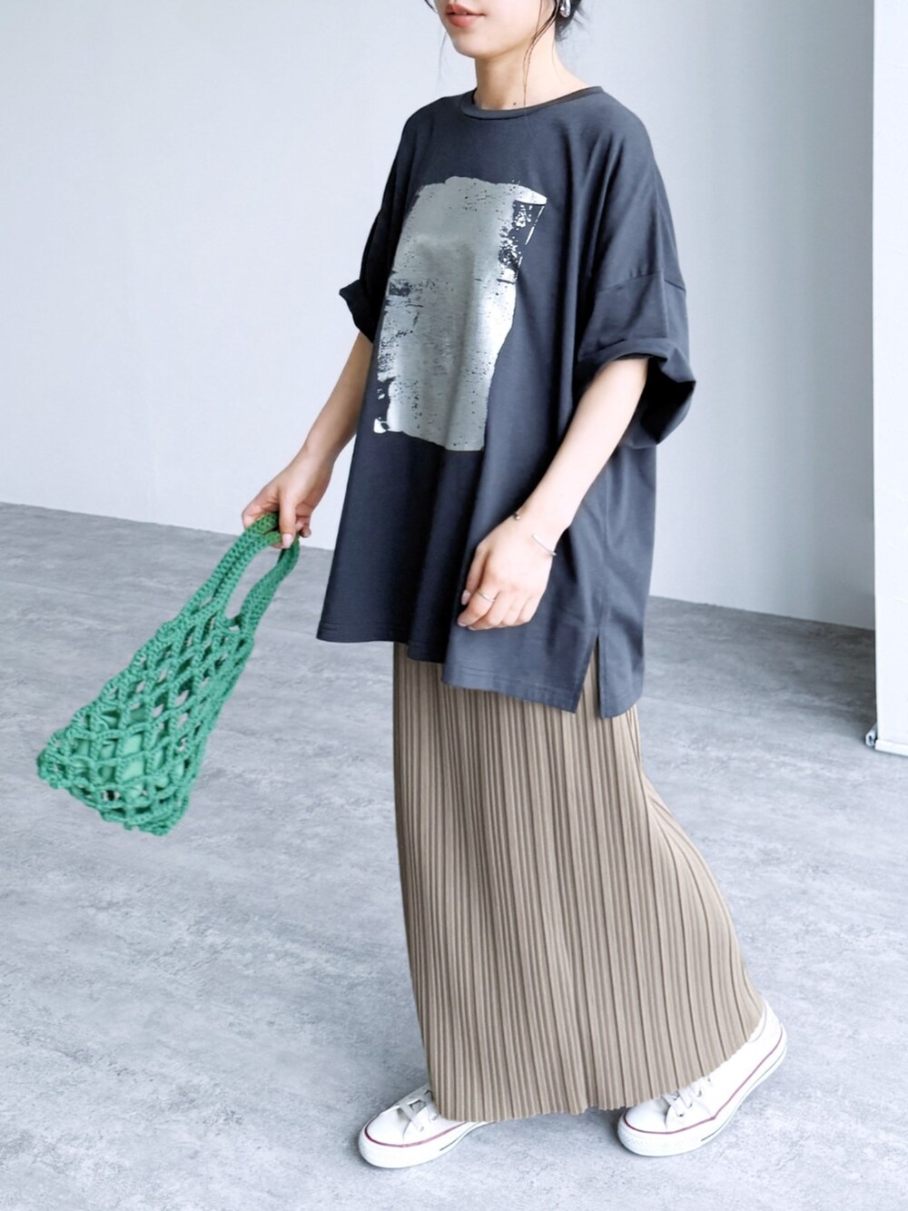 ベージュ系のスカート、グレー系のTシャツ/カットソーを着用したレディースの夏コーディネートの1枚目の写真