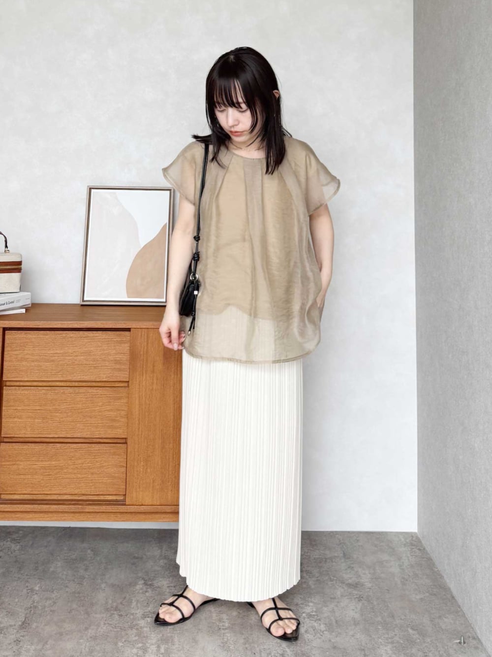 ホワイト系のスカート、ブラウン系のTシャツ/カットソーを着用したレディースの春コーディネートの1枚目の写真