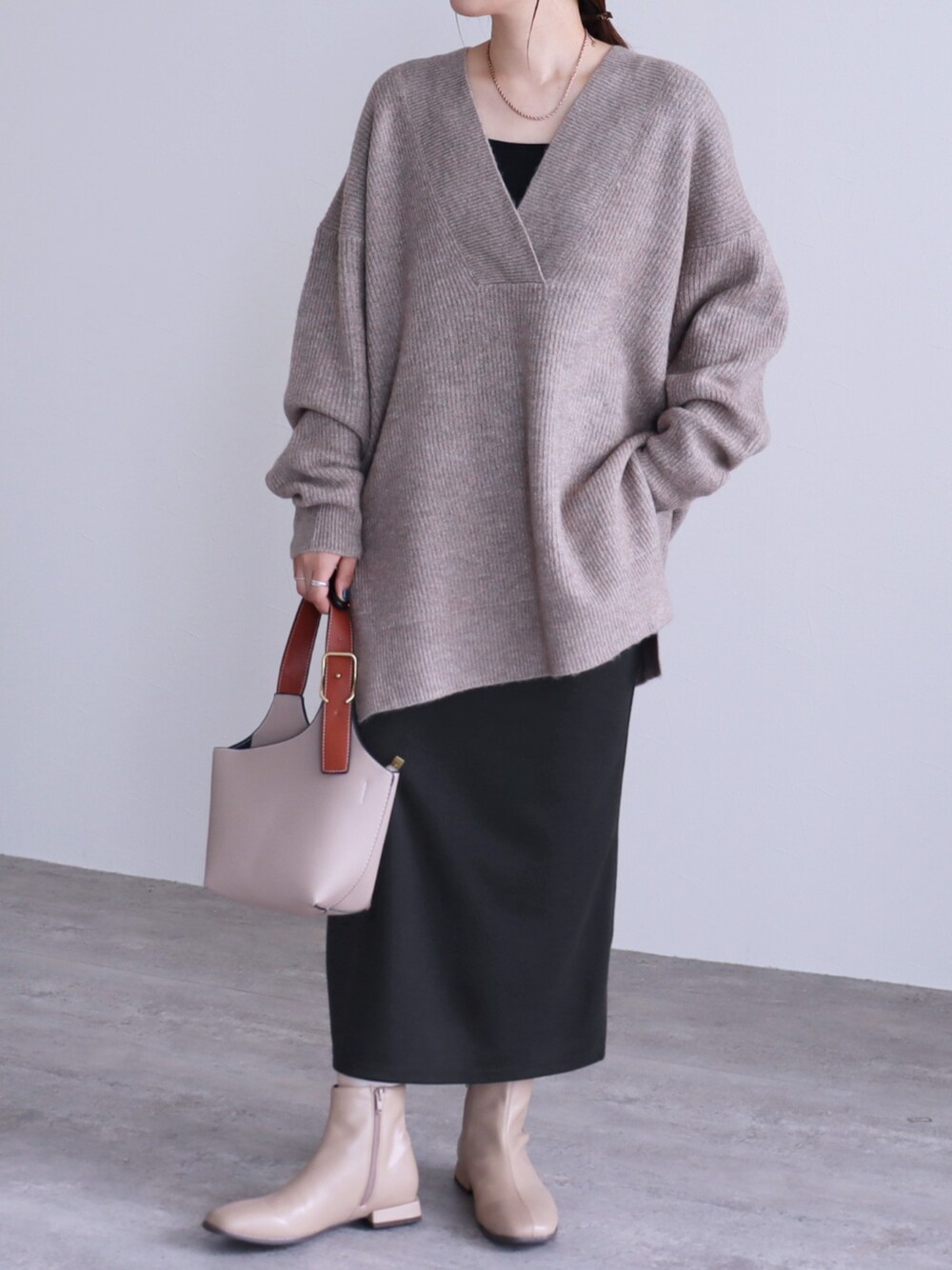 ブラック系のスカート、ブラウン系のニット/セーターを着用したレディースの秋コーディネートの1枚目の写真