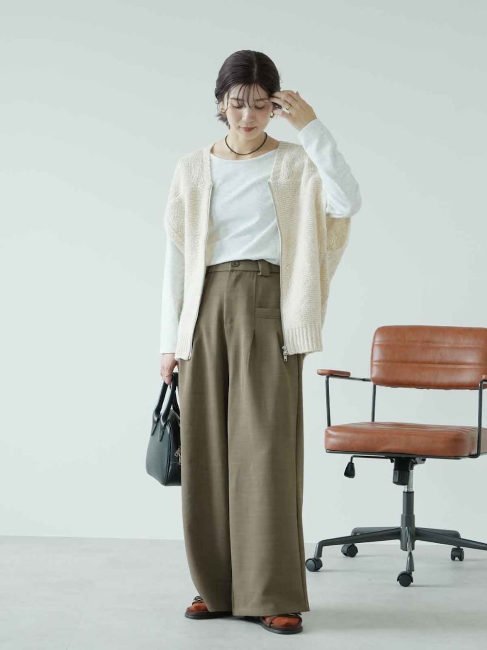 ホワイト系のベスト、ブラウン系のその他パンツ、ホワイト系のTシャツ/カットソーを着用したレディースの秋コーディネートの1枚目の写真