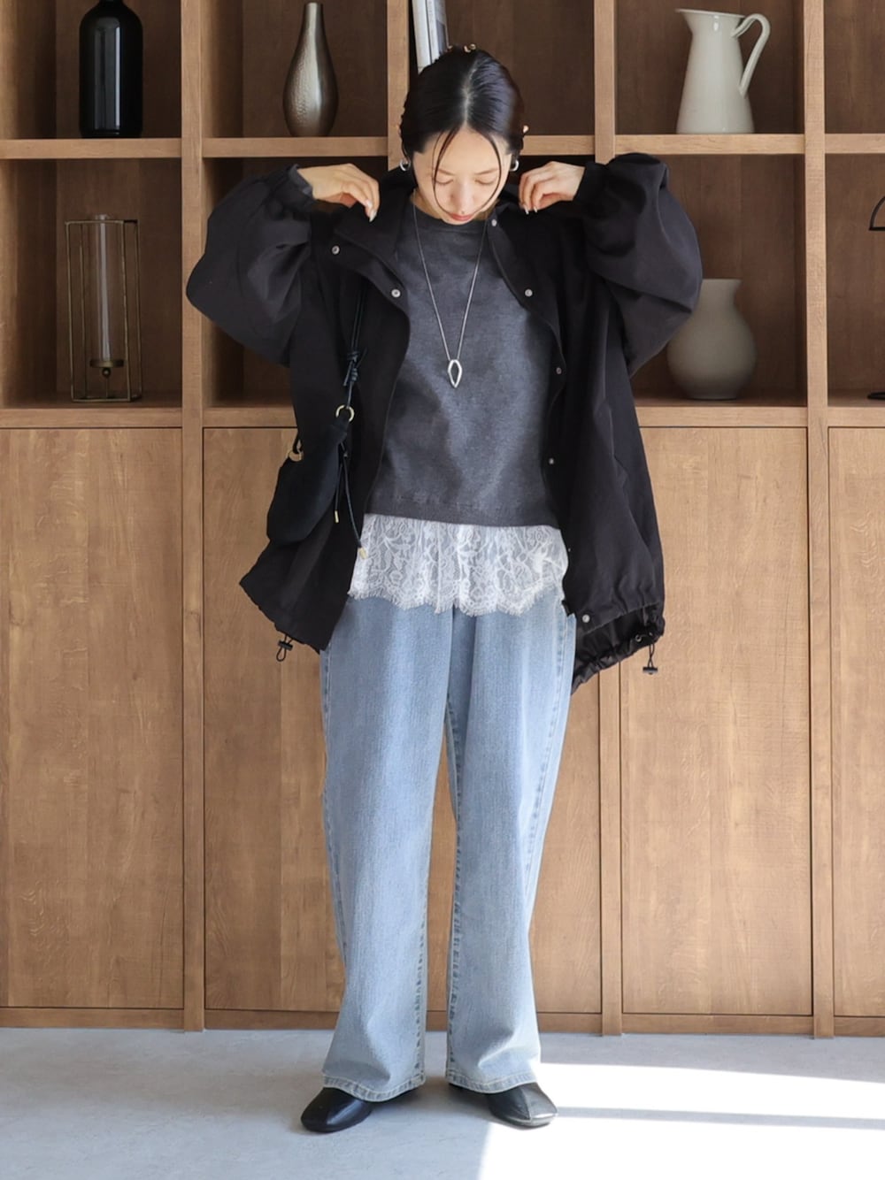 ブラック系のその他アウター、ブルー系のデニムパンツ、グレー系のニット/セーターを着用したレディースの秋コーディネートの1枚目の写真