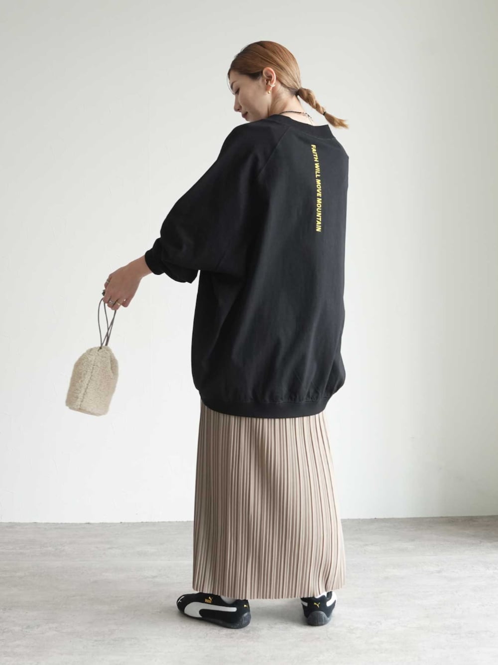 ブラック系のTシャツ/カットソー、ベージュ系のスカートを着用したレディースの秋コーディネートの1枚目の写真